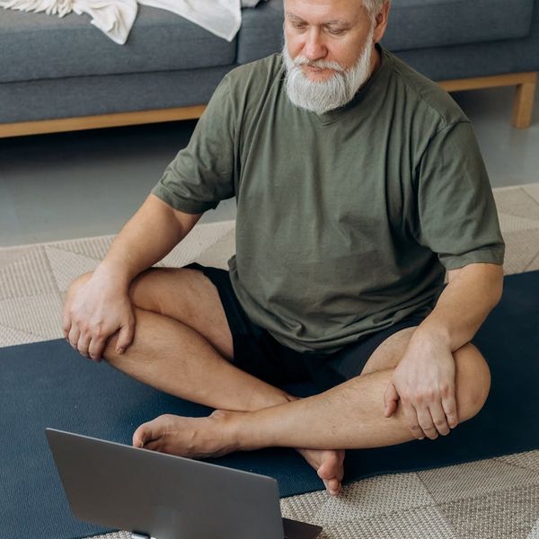Person stretching in a bright, sunlit room, suggesting vitality.
